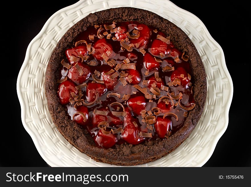 Black forest strawberry cheese cake on white plate with black background