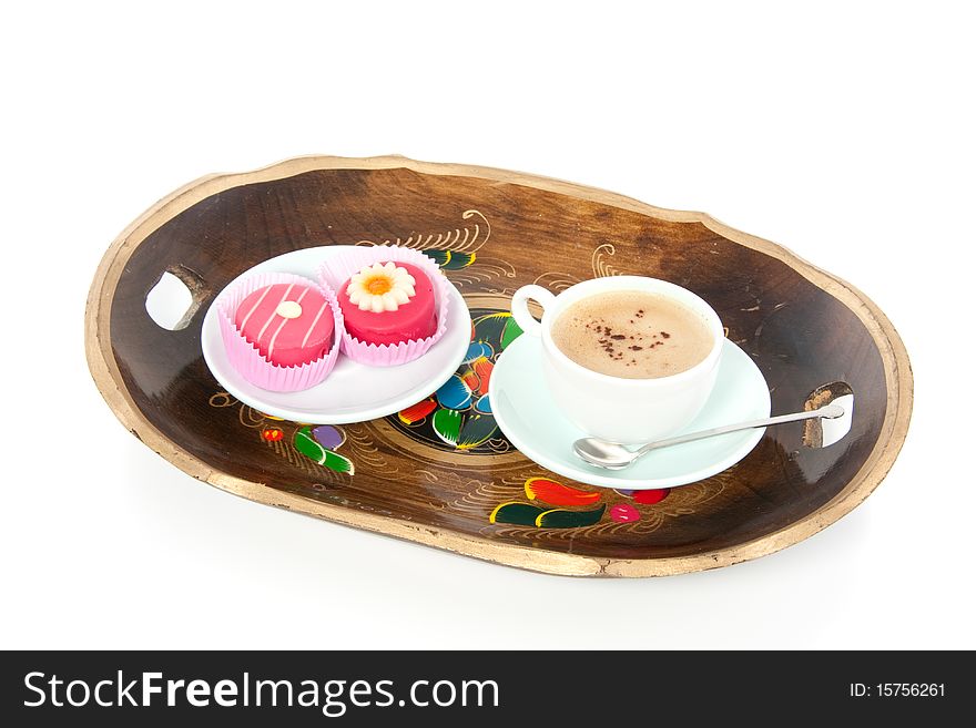 A wooden colorful tray with coffee and petit four isolated over white. A wooden colorful tray with coffee and petit four isolated over white