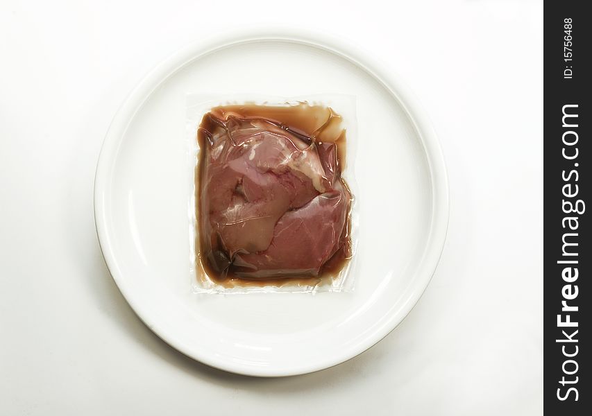 Vacuum packed meat on a plate. Vacuum packed meat on a plate