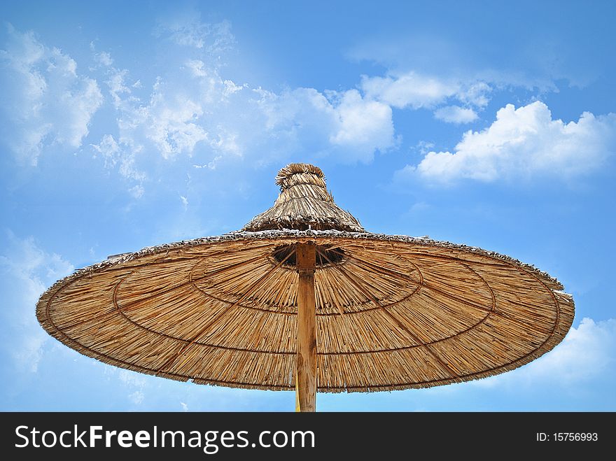 Nice summer detail on the beach, umbrella on the beach, nice clouds and sky. Nice summer detail on the beach, umbrella on the beach, nice clouds and sky