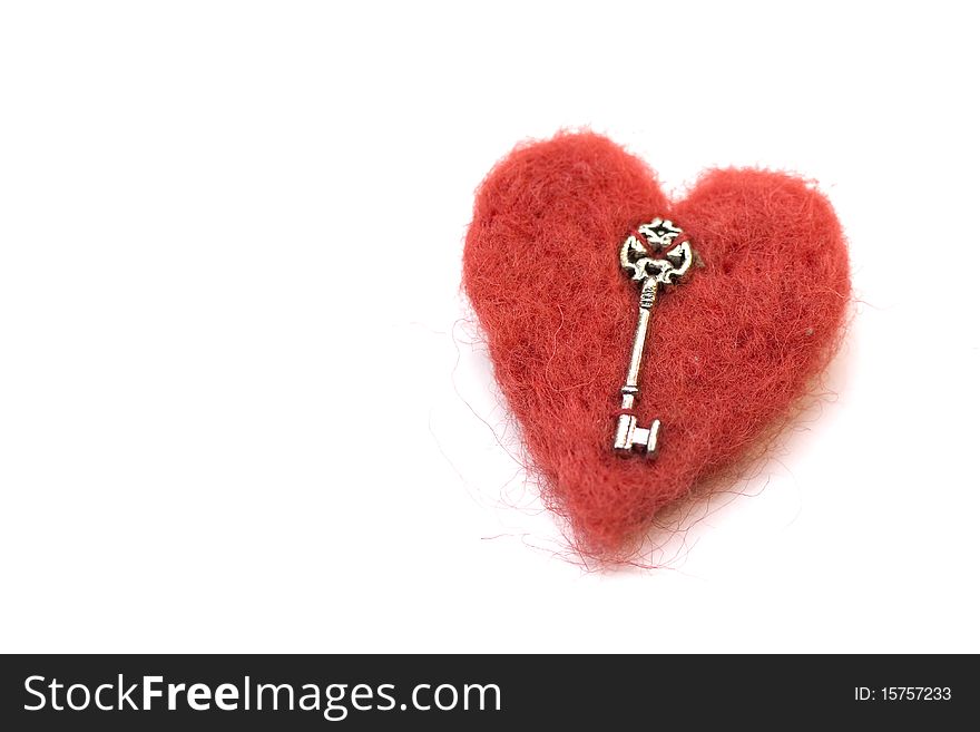 Red felt heart with key isolated on white