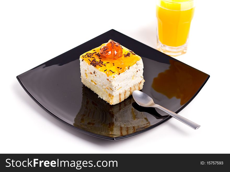Peach cake on black plate with juice aside