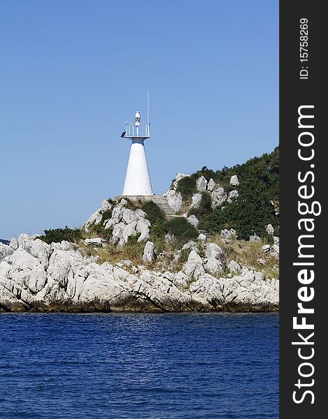 Bright white lighthouse on a small, rocky island