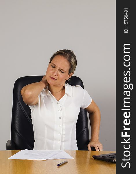 Tired businesswoman in the office massaging her neck