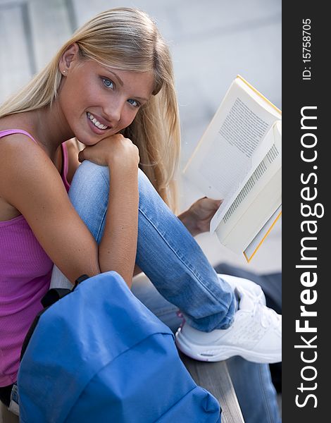 Happy female student outdoors, looking at camera