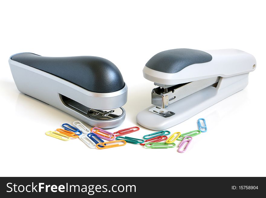 Two staplers and multicolored paper clips