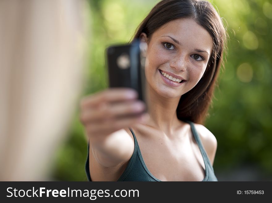 Beautiful teenage girls photographing with camera phone