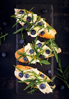 Bruschetta. Toast Crostini With Fresh Berries Blueberry And Honey, Brie Cheese, Arugula. Top View, Copy Space Royalty Free Stock Photography