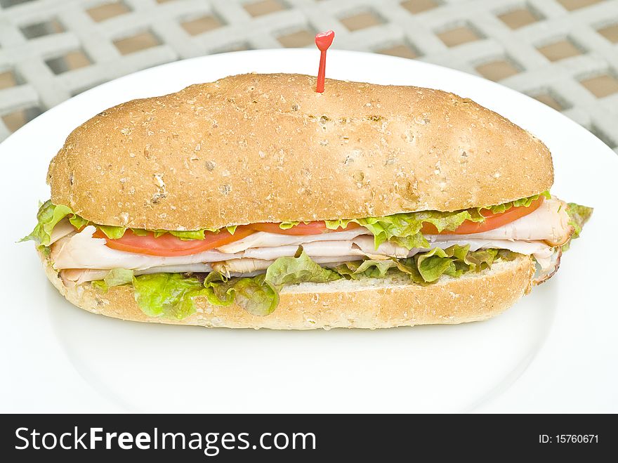 A turkey sandwich with tomato slices and lettuce. A turkey sandwich with tomato slices and lettuce.