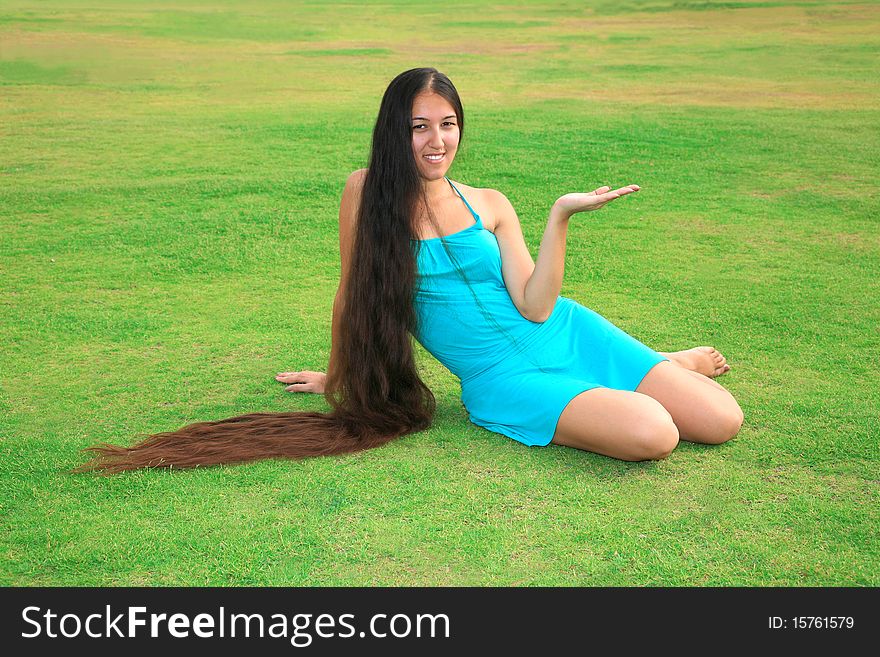Beautiful woman with long hair sitting on the grass and enjoying nature. Beautiful woman with long hair sitting on the grass and enjoying nature