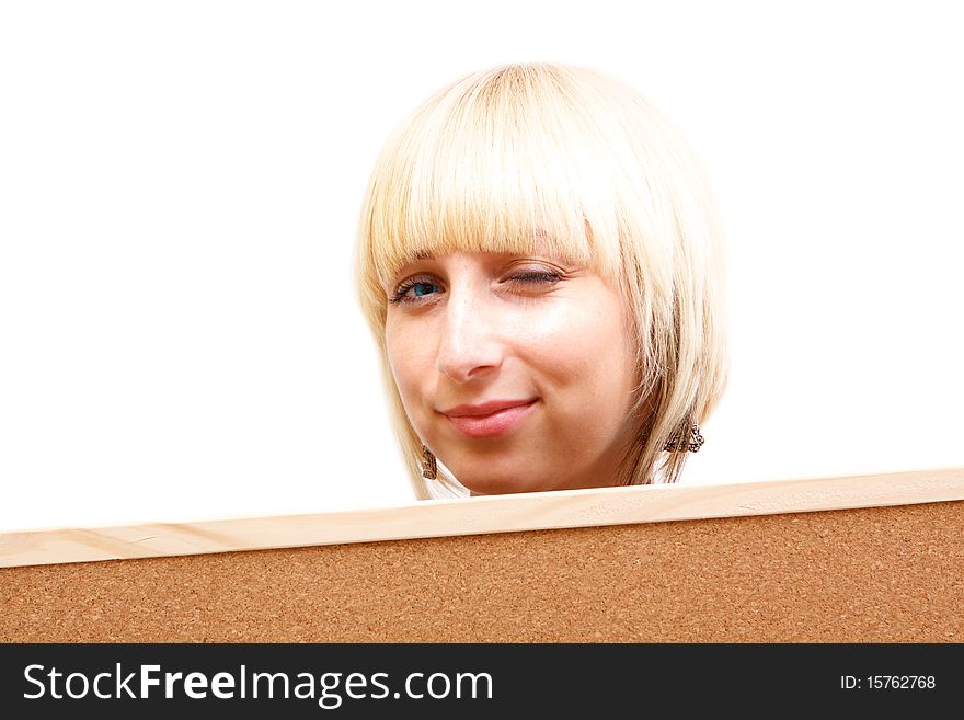 A beautiful flirting woman with blue eyes behind a corkboard