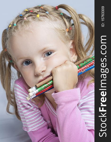 Cute little blond caucasian girl with pencils batch looking appear with calm and thoughtful look concentrated isolated. Cute little blond caucasian girl with pencils batch looking appear with calm and thoughtful look concentrated isolated