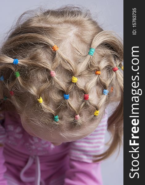 Head of young blond caucasian girl with unique hair tails design and pattern. from above view. isolated