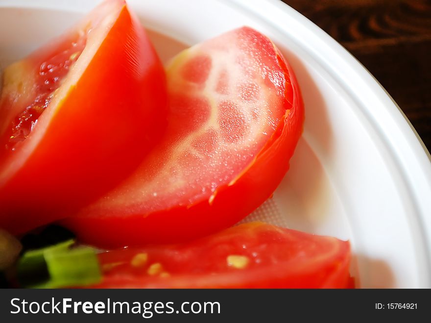 Red fresh cut  tomato on the plate closeup micro shoot. Red fresh cut  tomato on the plate closeup micro shoot.