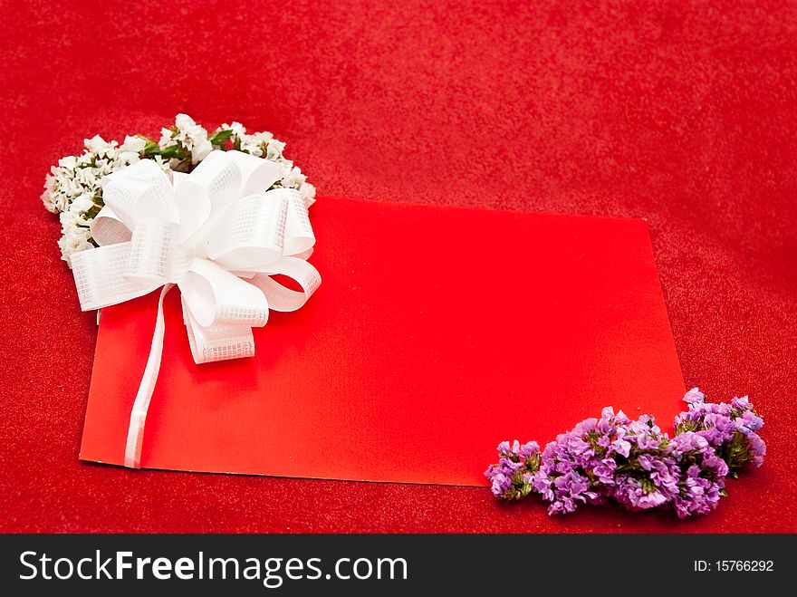 Greeting card with bow and flowers on red background