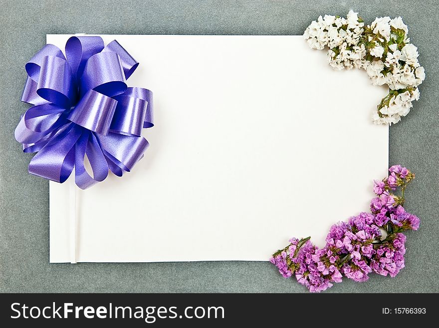 Greeting card with blue bow and flowers on grey background