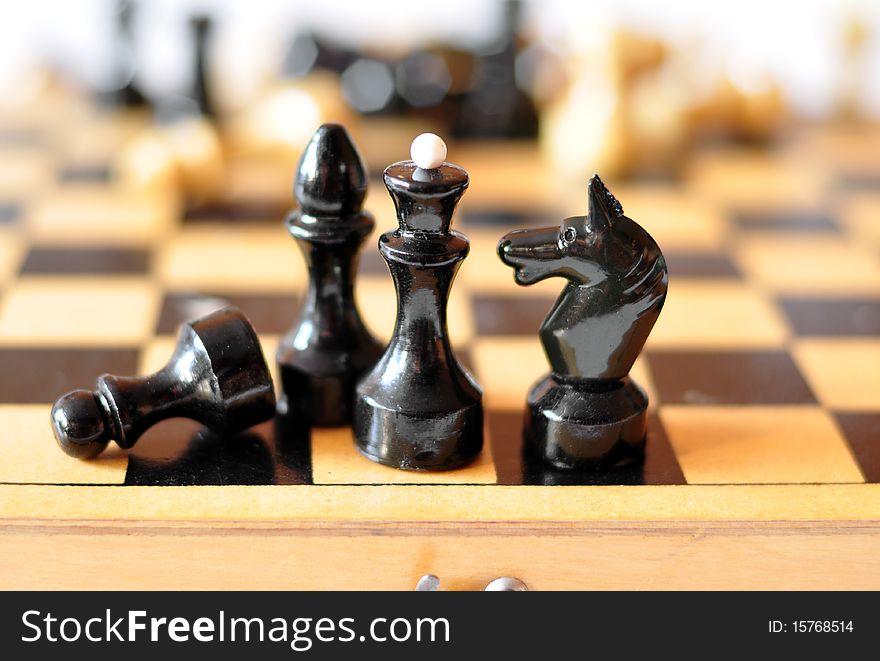 black figures stand on a chess-board