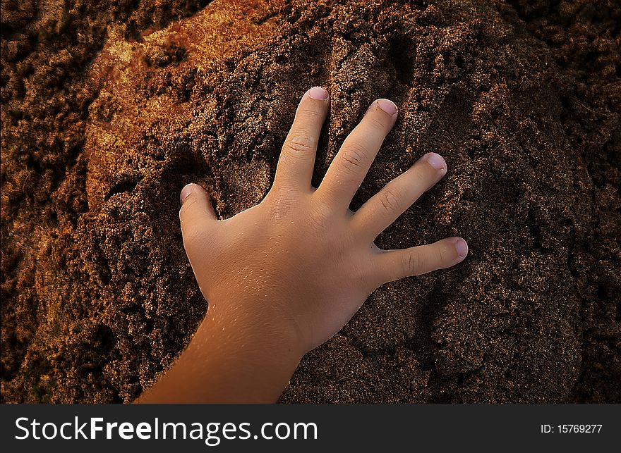 Childrens hand doing a print in sand. Childrens hand doing a print in sand