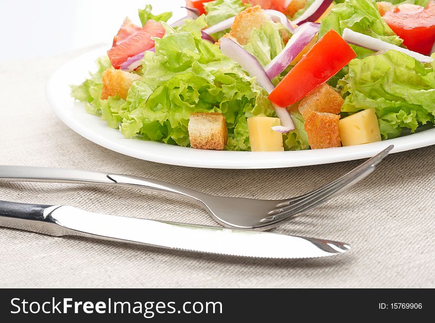 Salad serving on white plate with fork and knife. Salad serving on white plate with fork and knife