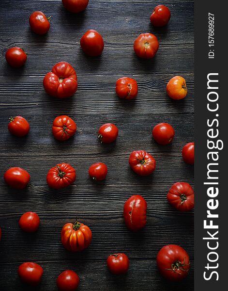Tomatoes on the old table. Red Food background. Tomatoes pattern. Top view of fresh vegetable on a dark wooden