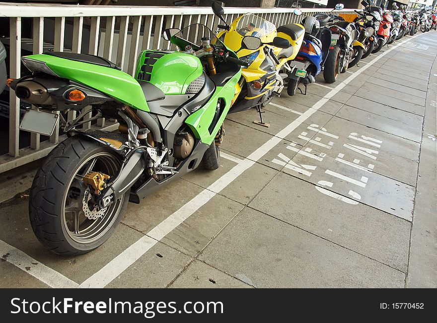 Line of motorbikes neatly parked on allocated spots on the footpath, Brisbane, Australia. Line of motorbikes neatly parked on allocated spots on the footpath, Brisbane, Australia