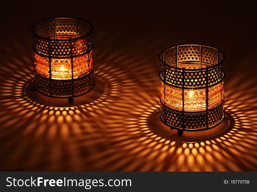 Two old-style candlesticks with flaming candle inside in the dark. Two old-style candlesticks with flaming candle inside in the dark