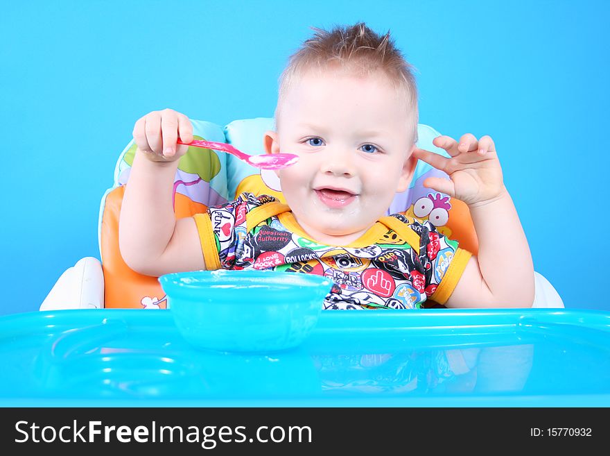 A child sits in a chair for feeding and eating. A child sits in a chair for feeding and eating