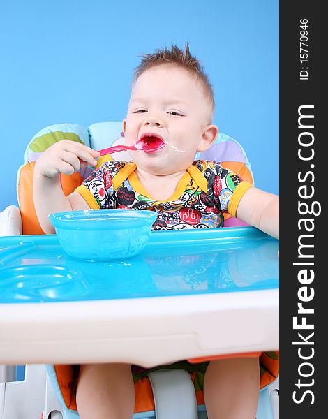 A child sits in a chair for feeding and eating. A child sits in a chair for feeding and eating