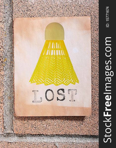 A lost sign with a yellow badminton shuttlecock hanging on a wall. A lost sign with a yellow badminton shuttlecock hanging on a wall.