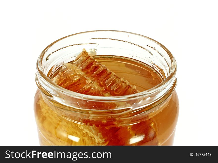 Glass jar full of honey with honeycomb, isolated on white. Glass jar full of honey with honeycomb, isolated on white