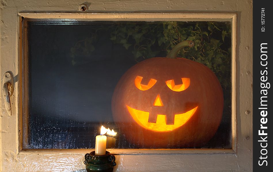 Glowing pumpkin head behind a night window looking at your room. Glowing pumpkin head behind a night window looking at your room