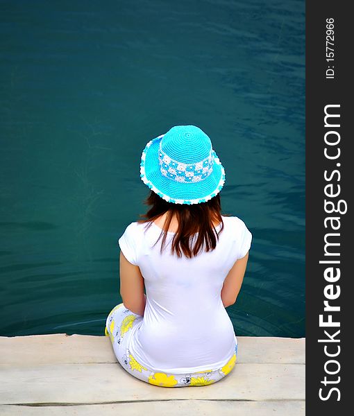 Young girl dabble in water by lake. Young girl dabble in water by lake