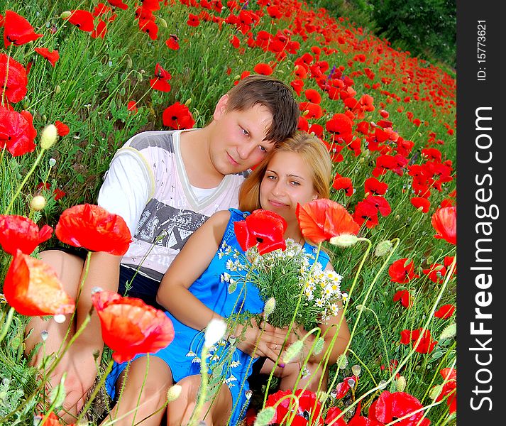 Loving couple is lying in the poppy field