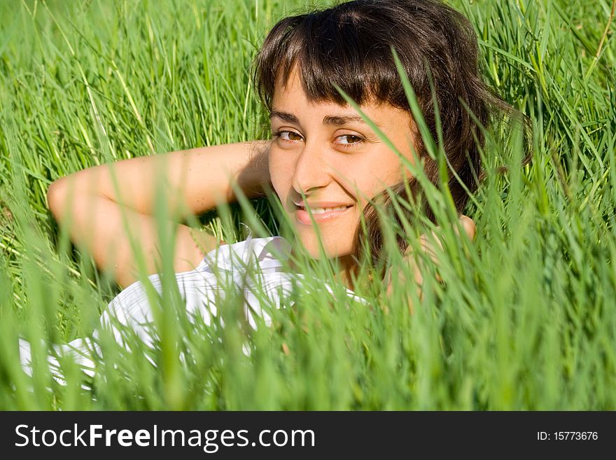 Close-up of a smilig young girl in the fresh grass. Close-up of a smilig young girl in the fresh grass