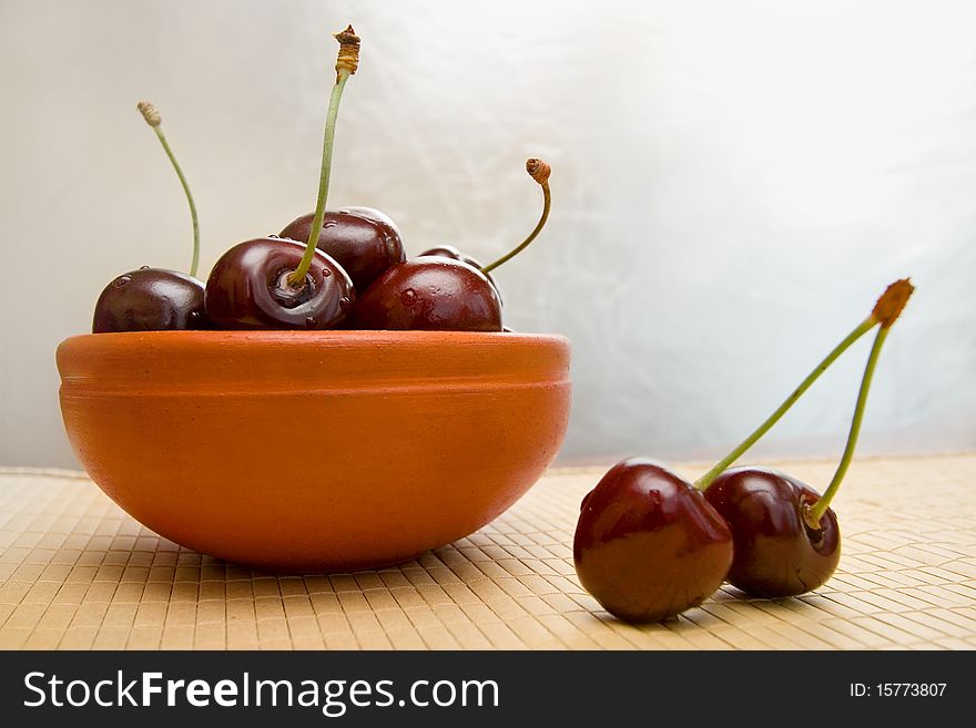 Ripe tasty cherries in the clay  bowl. Ripe tasty cherries in the clay  bowl