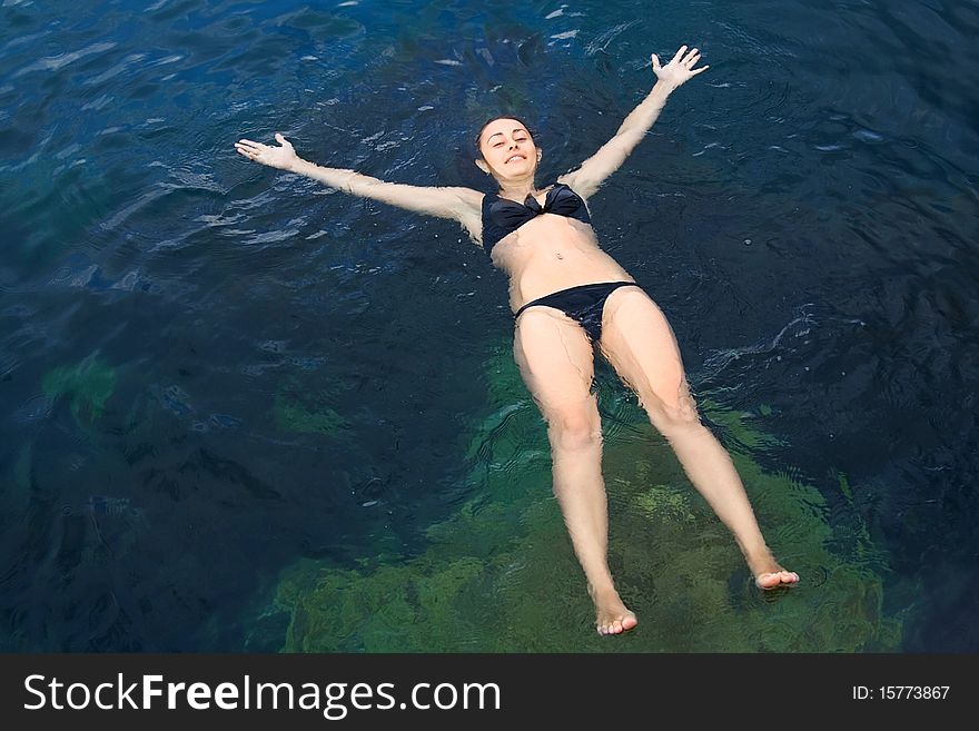 Young girl lying and relaxing on the sea water. Young girl lying and relaxing on the sea water