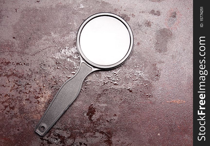 Magnifying glass on the rusty metal background. Magnifying glass on the rusty metal background