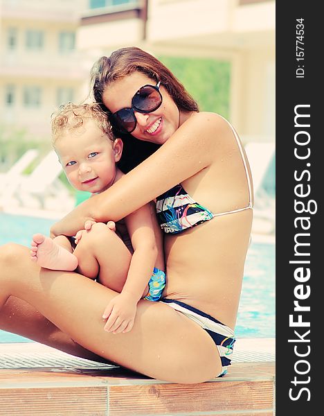 Portrait of happy woman and her sun in pool