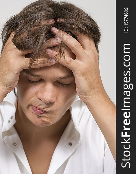 Closeup portrait of a upset young man with hand on his head