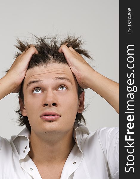 Closeup portrait of a upset young man with hand on his head