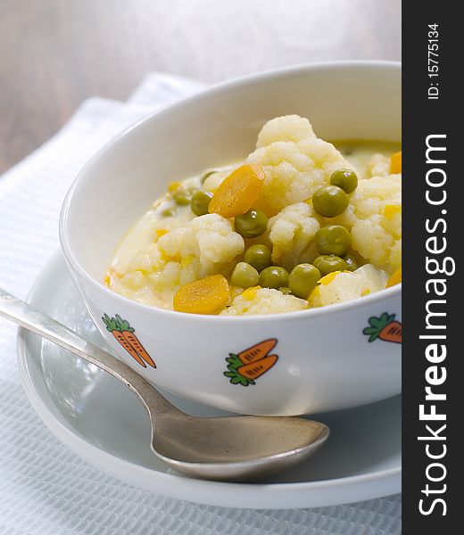 Bowl of vegetable soup on plate