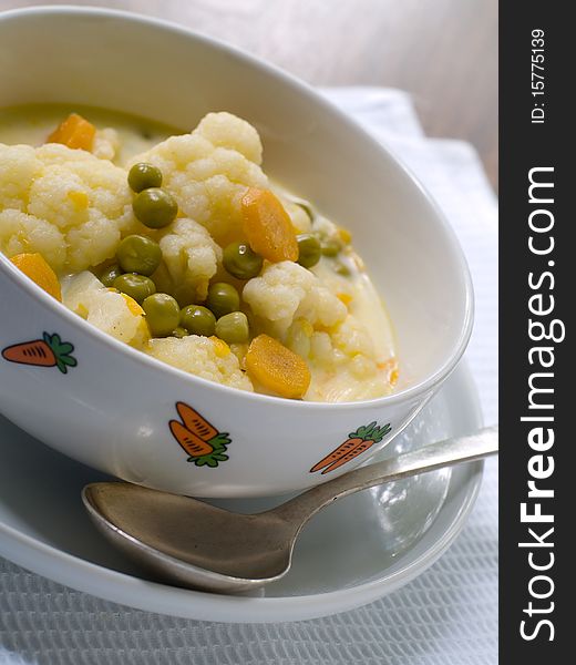 Bowl of vegetable soup on plate