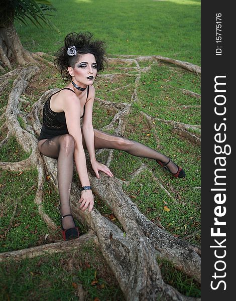 Female model pose on a tree roots in a tropical forest. Female model pose on a tree roots in a tropical forest.