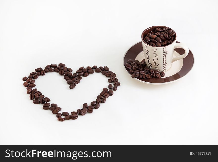 A heart filled cup of coffee with the beans shaped into a heart.  We all love coffee. A heart filled cup of coffee with the beans shaped into a heart.  We all love coffee.