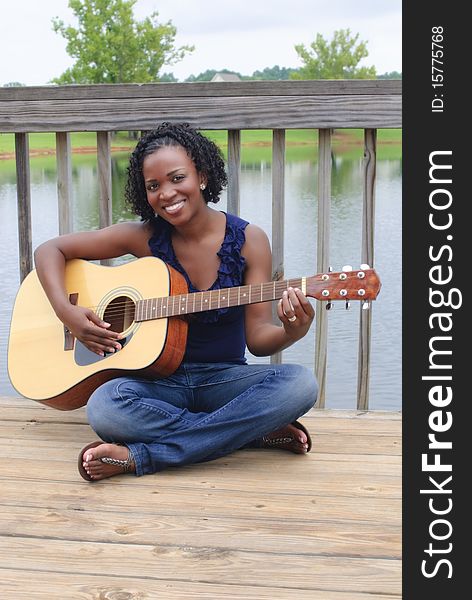 Pretty african-american woman with acoustic guitar. Pretty african-american woman with acoustic guitar