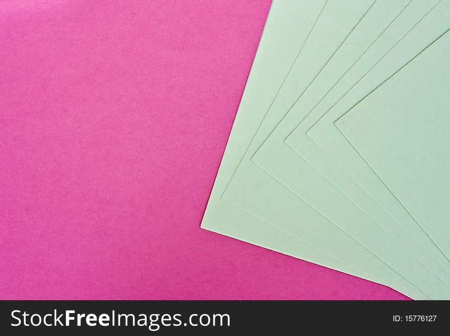 a background of pink and white paper spread out to form a pattern. a background of pink and white paper spread out to form a pattern