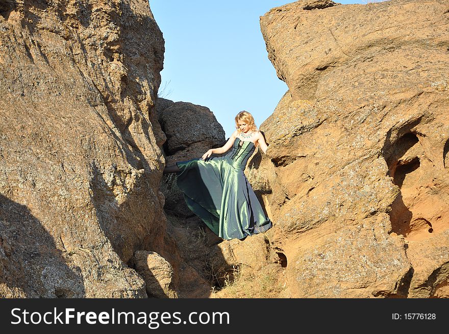 Attractive woman standing in the stony ravine and lift her leg. Attractive woman standing in the stony ravine and lift her leg
