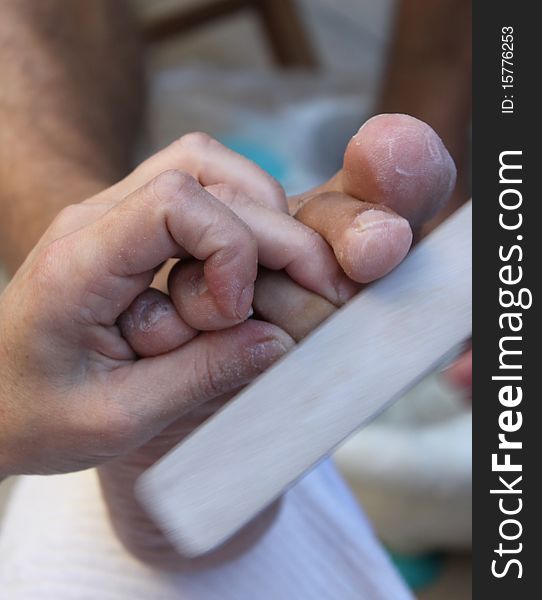 beautician giving pedicure on mans foot