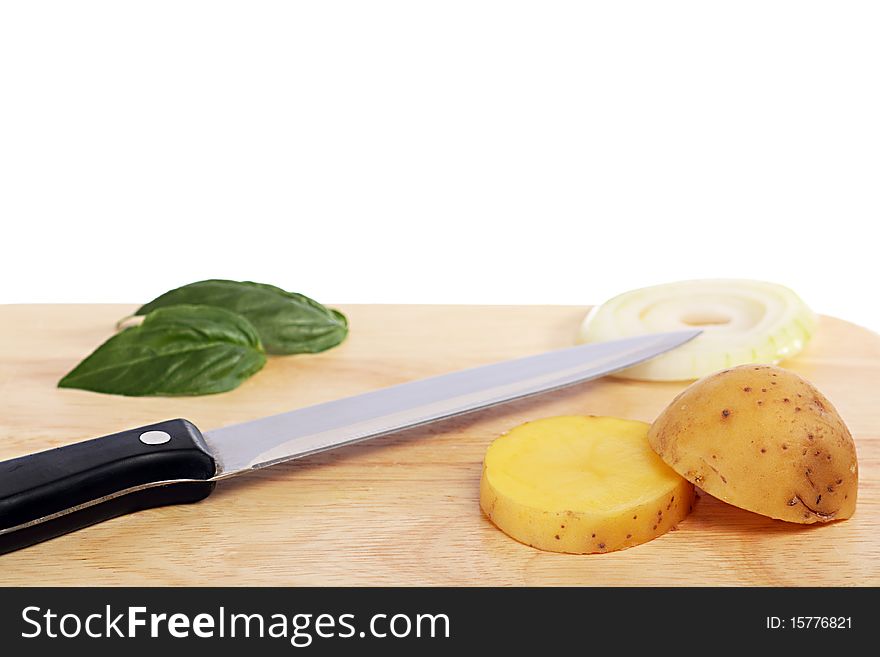 Knife next to potatoes, onions and basil. Knife next to potatoes, onions and basil