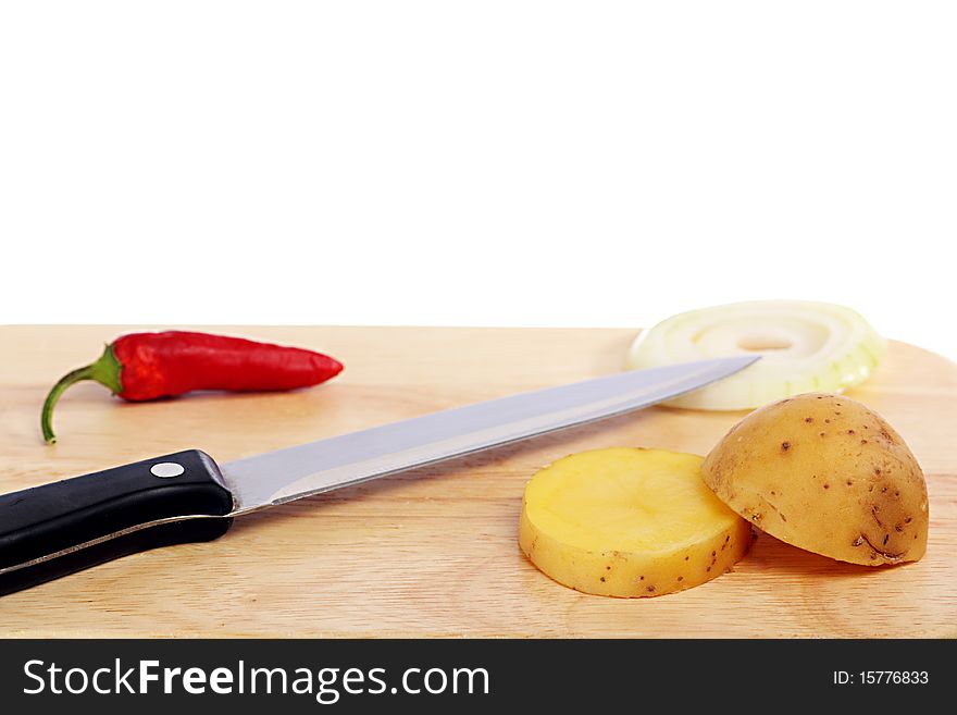 Knife next to potatoes, onions and chili. Knife next to potatoes, onions and chili